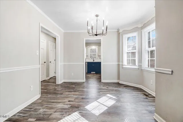 a view of empty room with wooden floor and windows