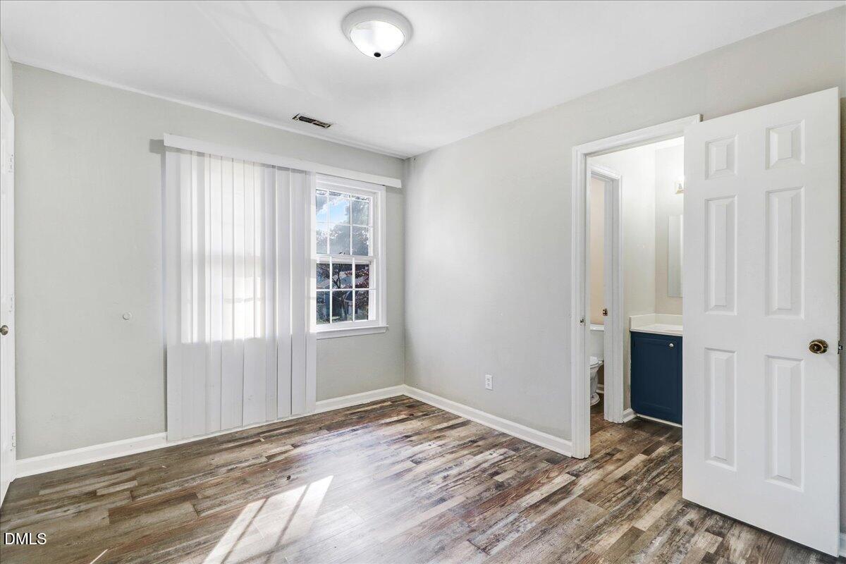 4715 Mallory Court Raleigh, NC 27616 - Photo 18 of 31 an empty room with window and wooden floor