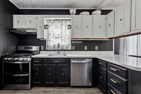 a kitchen with stainless steel appliances granite countertop a stove a sink and a microwave