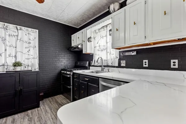 a kitchen with stainless steel appliances granite countertop a sink stove and cabinets