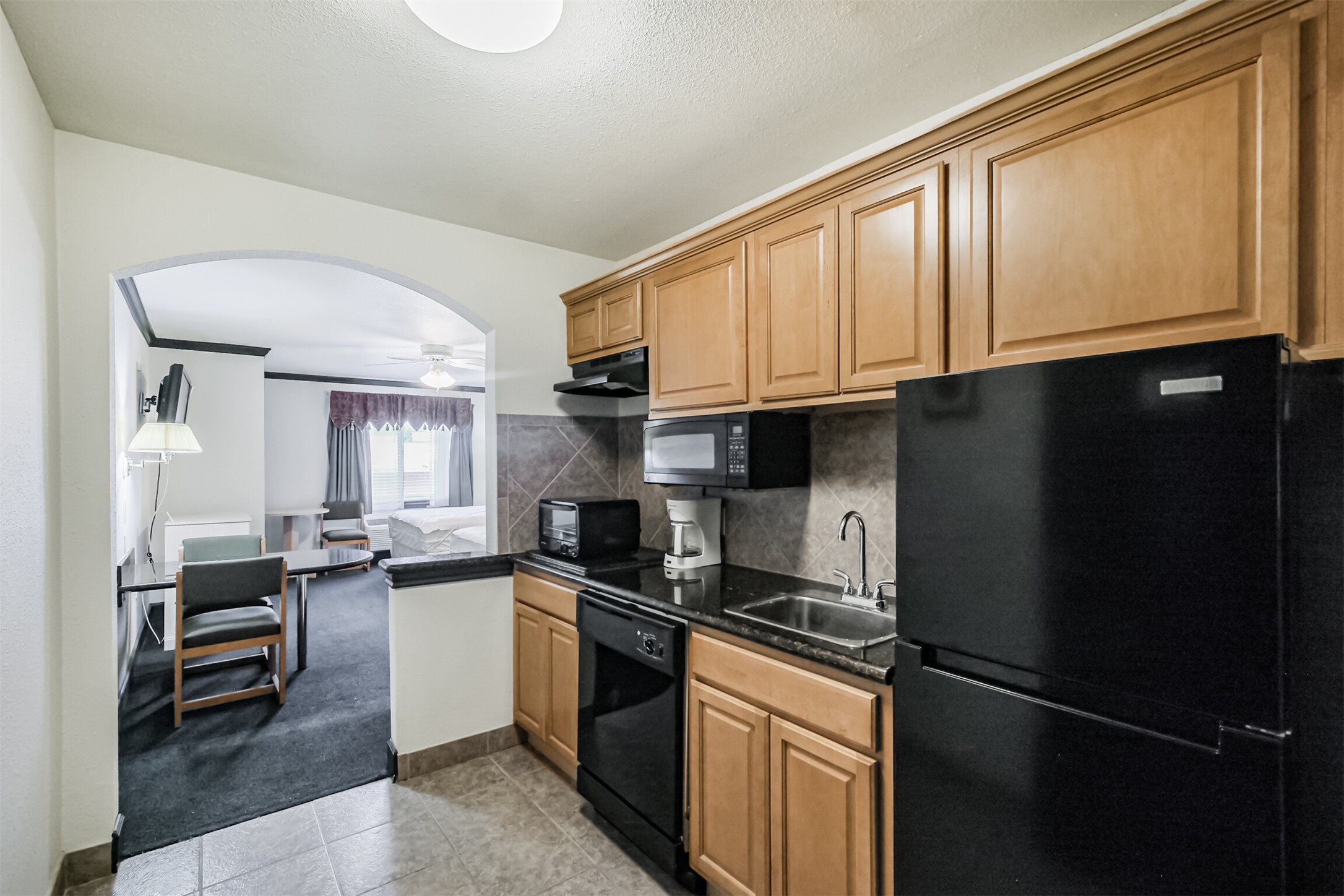 1025 Swanson Street, Unit 210 Houston, TX 77030 - Photo 9 of 19 a kitchen with granite countertop stainless steel appliances a sink a stove cabinets and a window