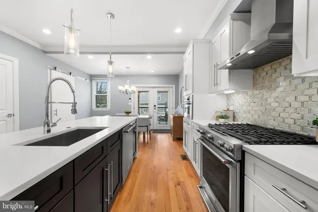 a kitchen with stainless steel appliances a sink stove and cabinets