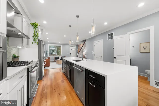 a large kitchen with stainless steel appliances a lot of counter space and wooden floor