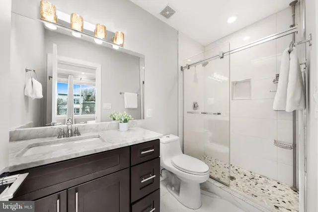 a bathroom with a sink a toilet and shower