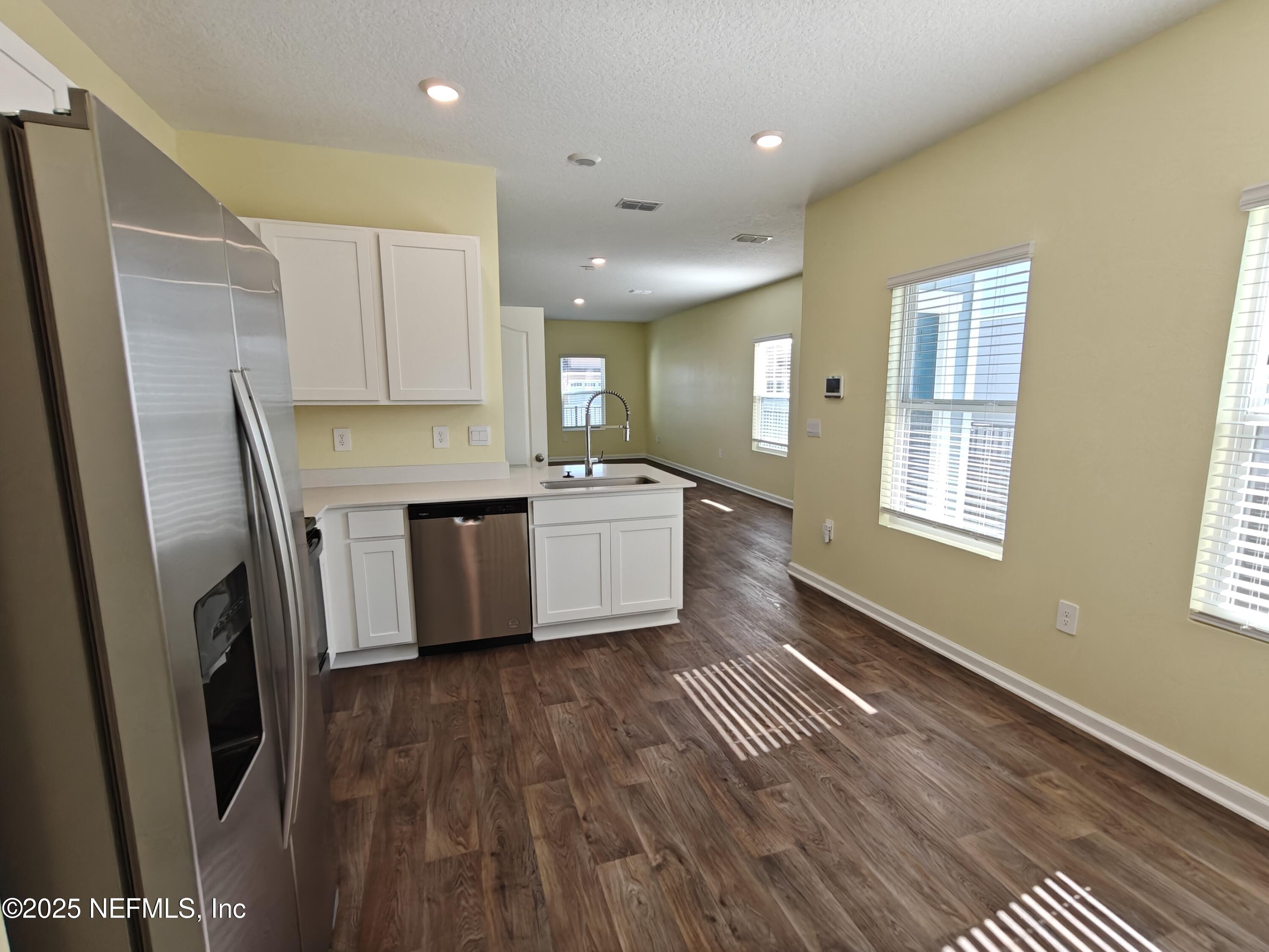 1731 Bridger Trace Middleburg, FL 32068 - Photo 14 of 43 a kitchen with stainless steel appliances a refrigerator sink and wooden floor