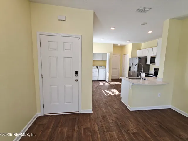 a kitchen with stainless steel appliances a refrigerator sink and wooden floor