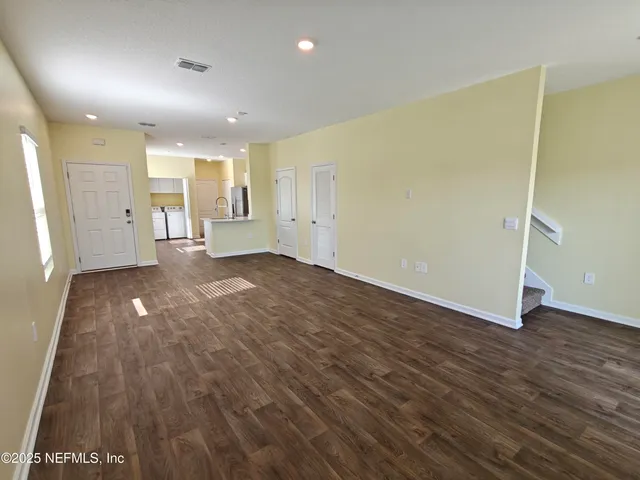 a view of a big room with windows and chandelier fan