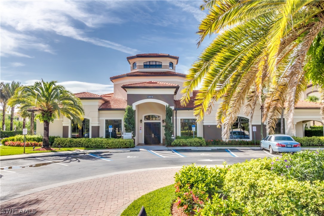 13010 Positano Circle, Unit 101 Naples, FL 34105 - Photo 21 of 26 a front view of a building with a garden