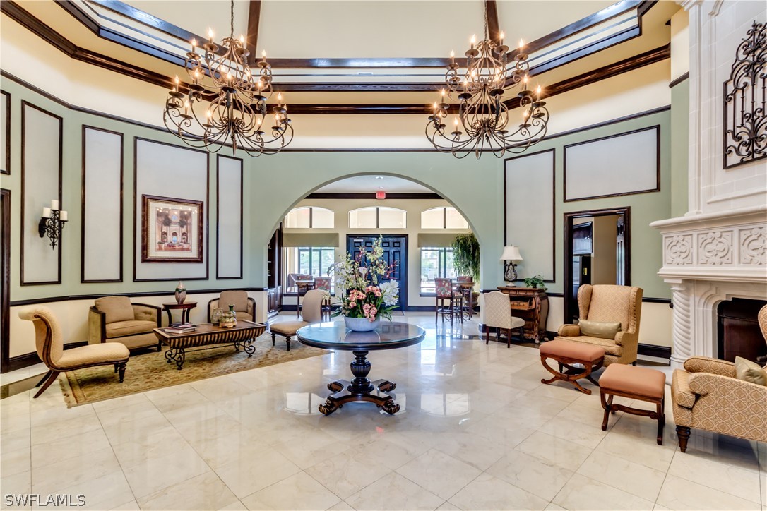 13010 Positano Circle, Unit 101 Naples, FL 34105 - Photo 22 of 26 a living room with furniture and a chandelier