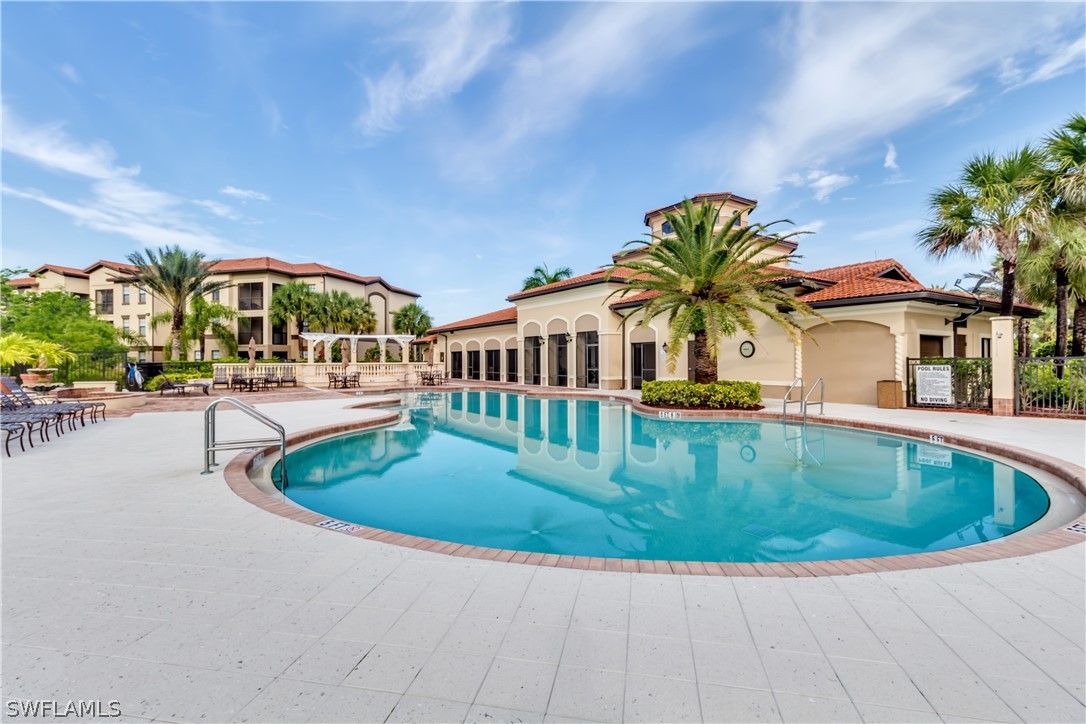 13010 Positano Circle, Unit 101 Naples, FL 34105 - Photo 23 of 26 a view of swimming pool with outdoor seating and plants