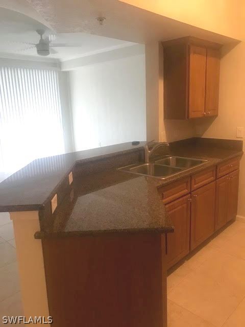 13010 Positano Circle, Unit 101 Naples, FL 34105 - Photo 3 of 26 a kitchen with a sink and cabinets