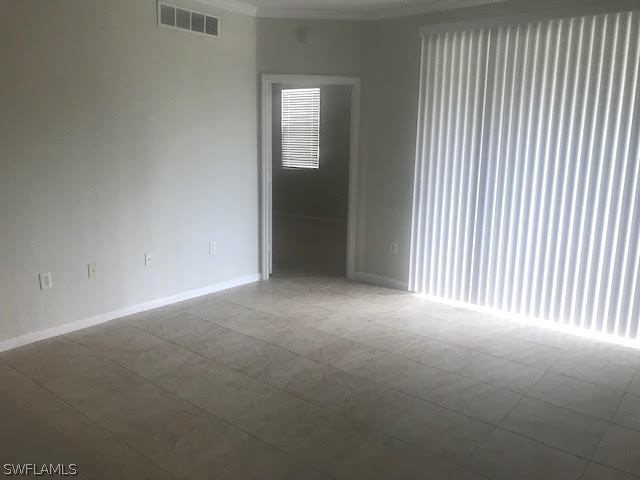 13010 Positano Circle, Unit 101 Naples, FL 34105 - Photo 8 of 26 a view of an empty room with a window