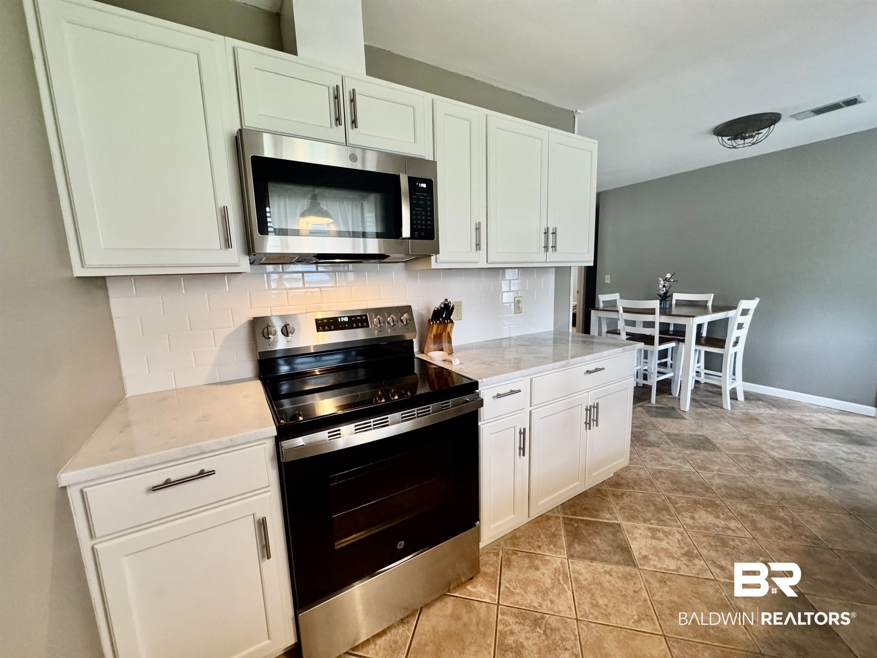 2274 Foshee Road Brewton, AL 36426 - Photo 11 of 23 Kitchen with appliances with stainless steel finishes, tasteful backsplash, white cabinetry, and light stone counters