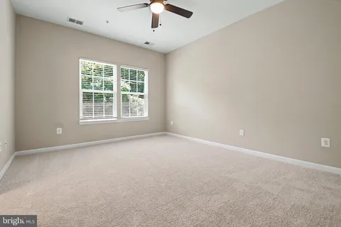 an empty room with a window and a kitchen