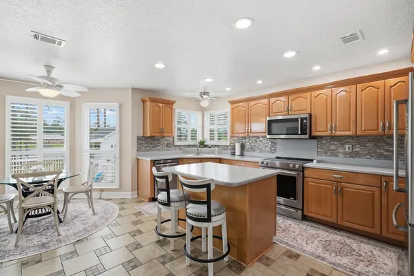 a kitchen with granite countertop lots of counter top space dining table and stainless steel appliances
