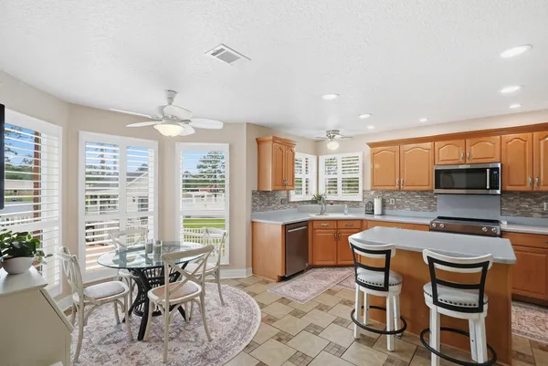 a kitchen with a sink and chairs