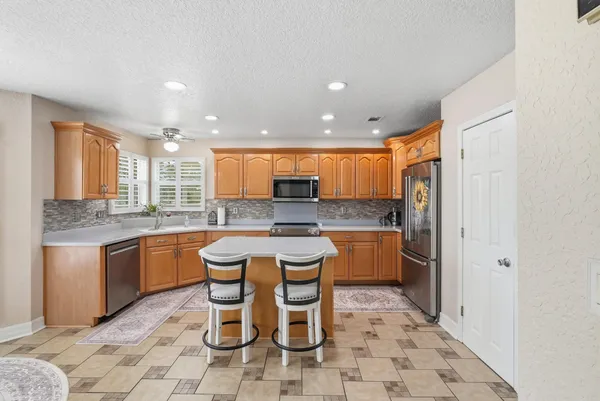 a kitchen with sink a refrigerator and microwave