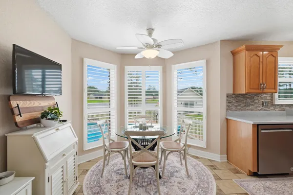 a kitchen with a dining table cabinets appliances and a window