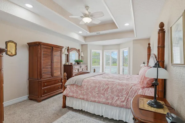 a bedroom with a bed and dresser with mirror