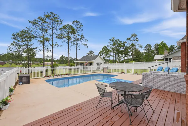 a view of a house with pool and chairs