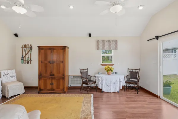 a living room with furniture a wooden floor and next to a window