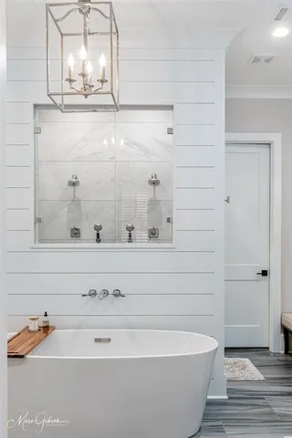 a bathroom with a tub sink and mirror