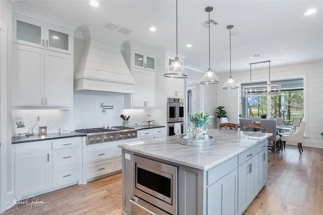 a kitchen with stainless steel appliances kitchen island granite countertop a sink a stove and cabinets
