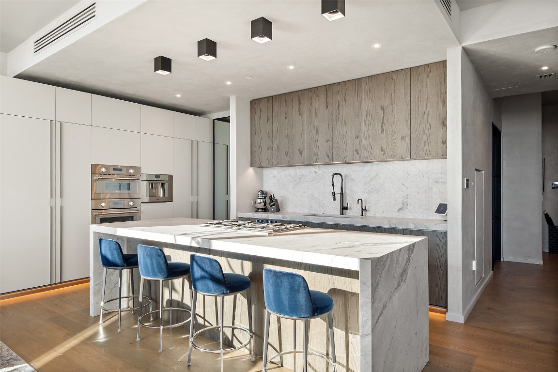 210 Lavaca Street, Unit 2301 Austin, TX 78701 - Photo 15 of 40 a kitchen with a stove a table and chairs