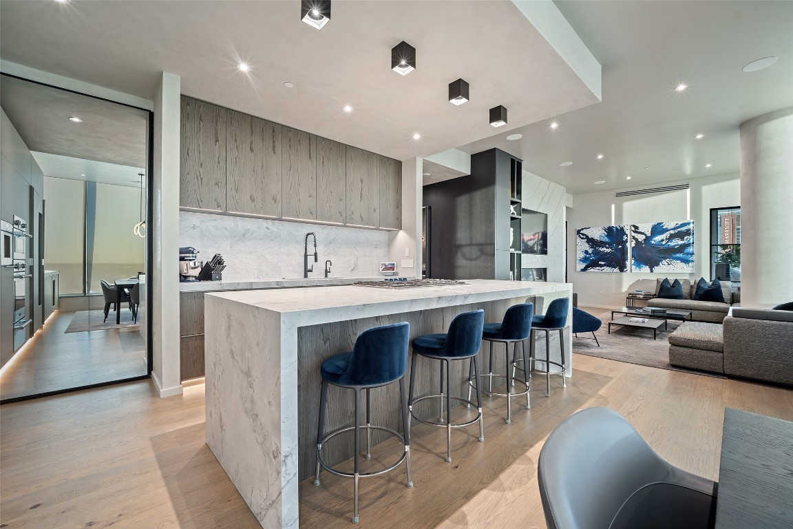 210 Lavaca Street, Unit 2301 Austin, TX 78701 - Photo 18 of 40 a kitchen with stainless steel appliances kitchen island granite countertop a stove a sink a dining table and chairs