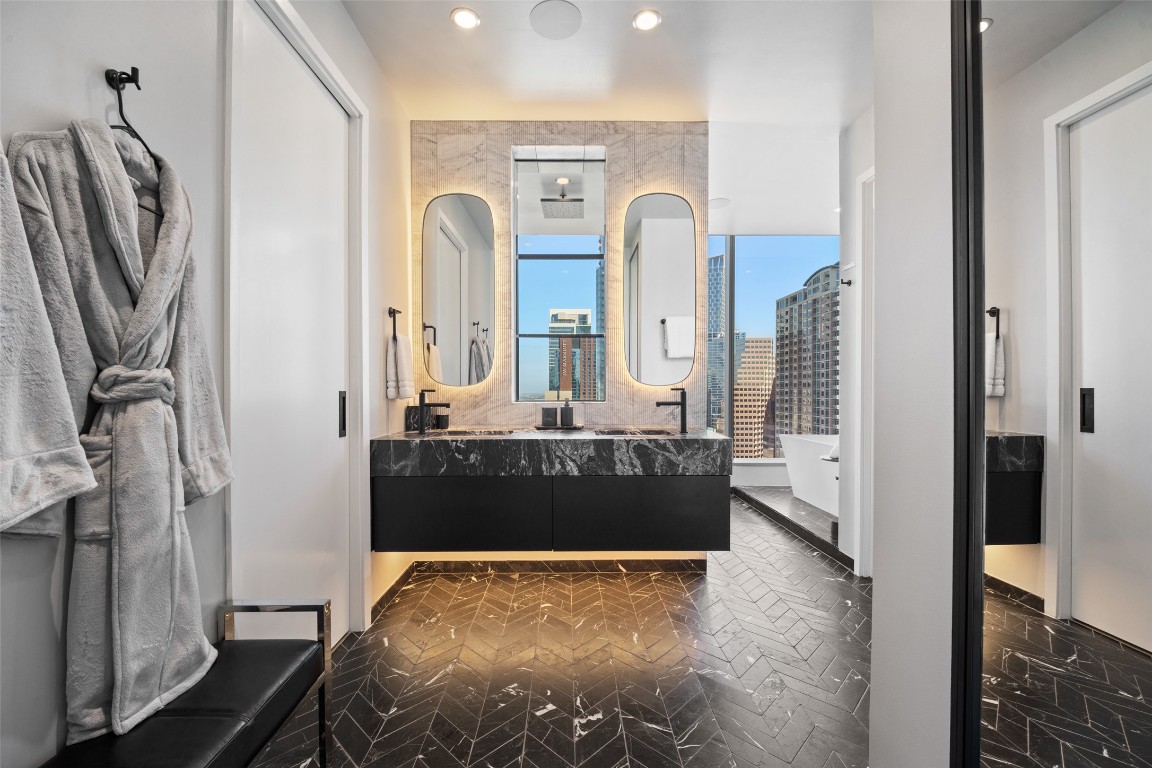 210 Lavaca Street, Unit 2301 Austin, TX 78701 - Photo 23 of 40 a bathroom with a tub a double vanity sink and mirror