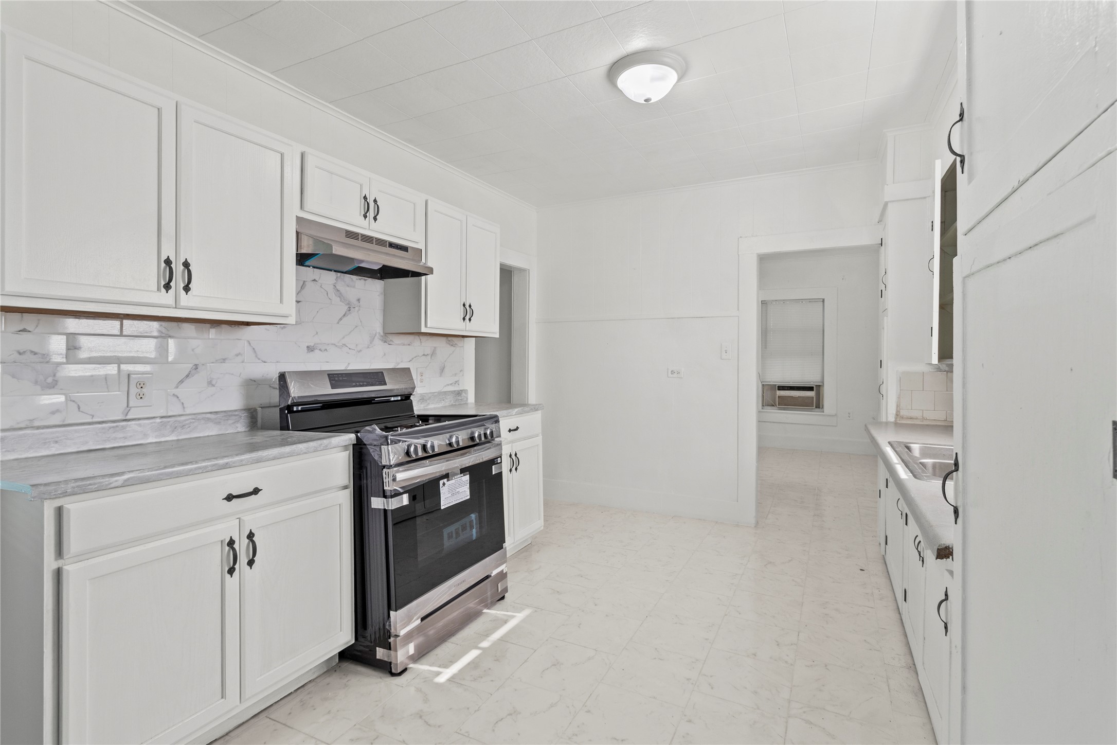 706 East Hunnicutt Street Baytown, TX 77520 - Photo 4 of 12 a kitchen with white cabinets and white appliances
