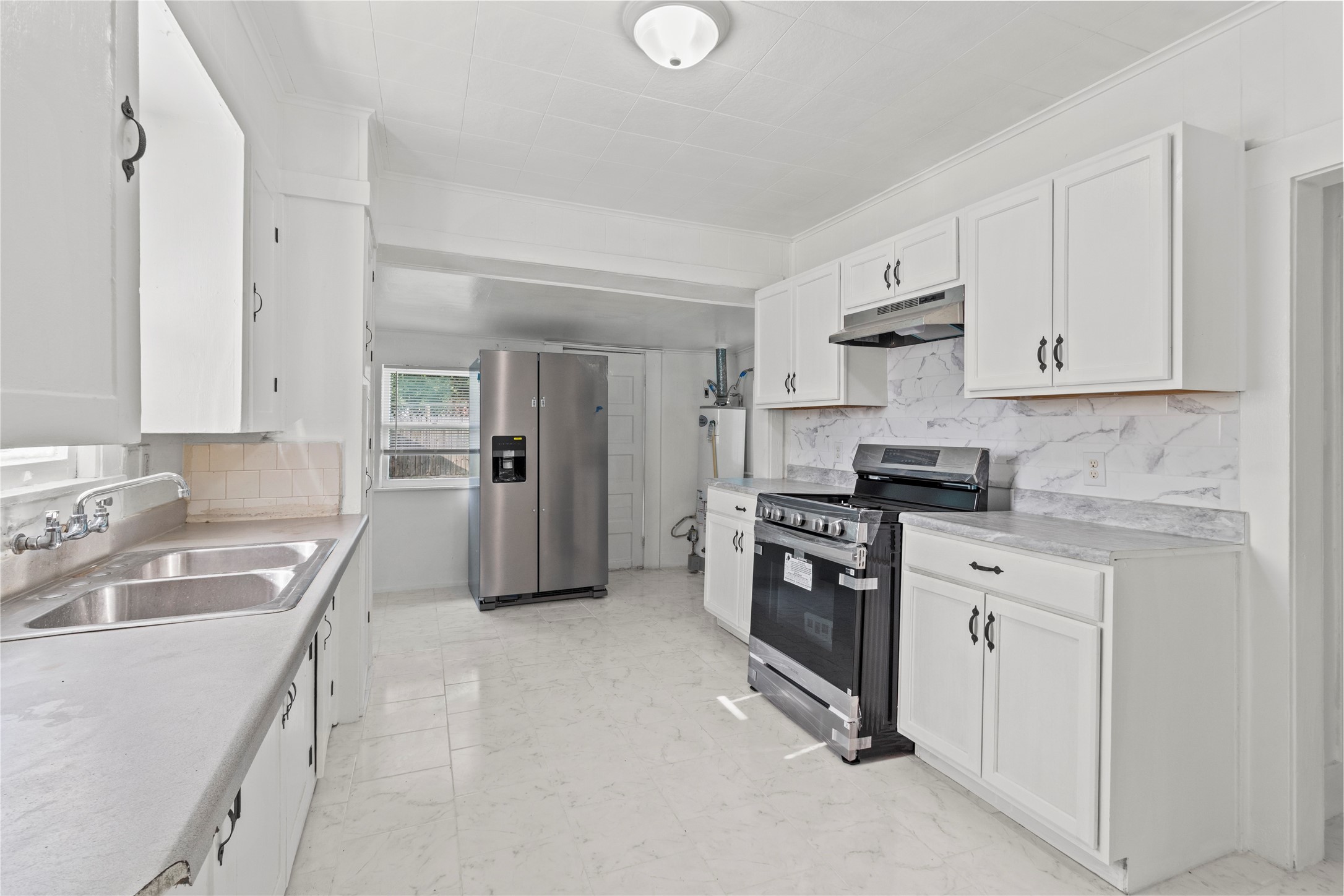 706 East Hunnicutt Street Baytown, TX 77520 - Photo 5 of 12 a kitchen with white cabinets and appliances