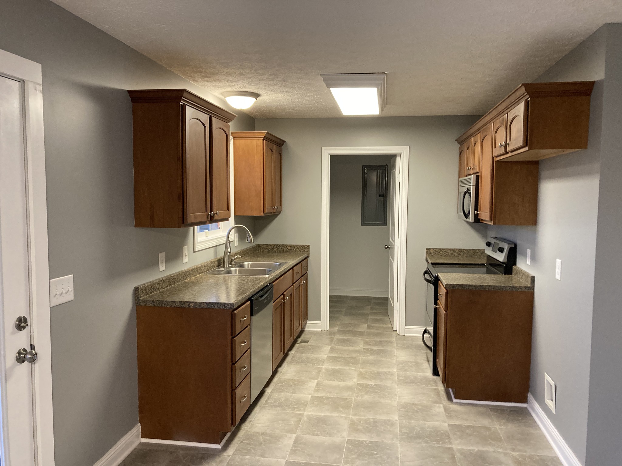 128 T G T Road Portland, TN 37148 - Photo 4 of 8 a kitchen with stainless steel appliances granite countertop a stove a sink and a refrigerator