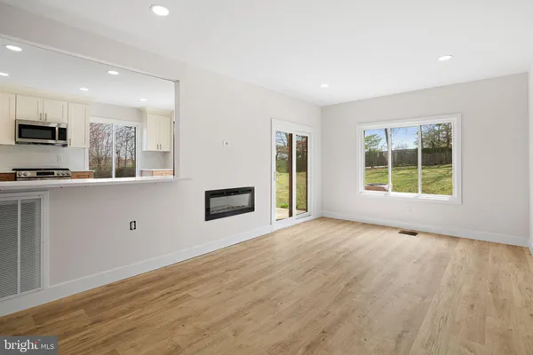 a bathroom with a bathtub shower sink vanity mirror and toilet