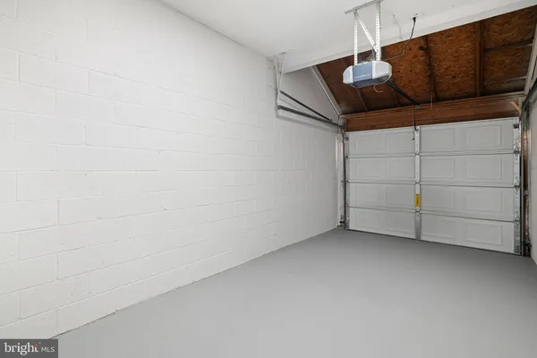 a backyard of a house with table and chairs and wooden fence