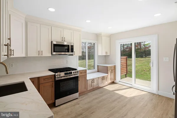a kitchen with stainless steel appliances granite countertop a stove a sink and a refrigerator