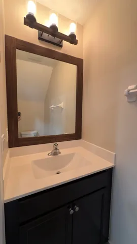 a bathroom with a granite countertop sink a large mirror and a shower