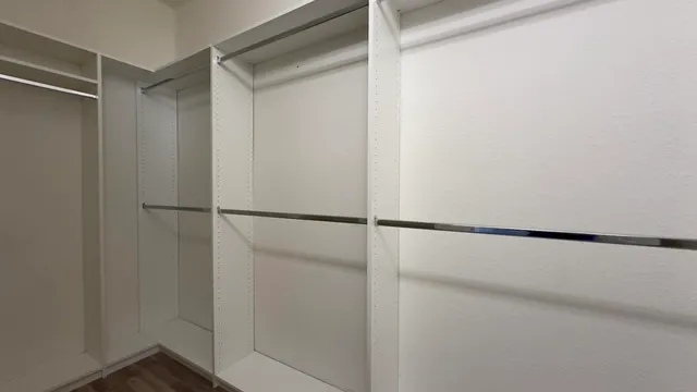 a view of walk in closet with empty racks