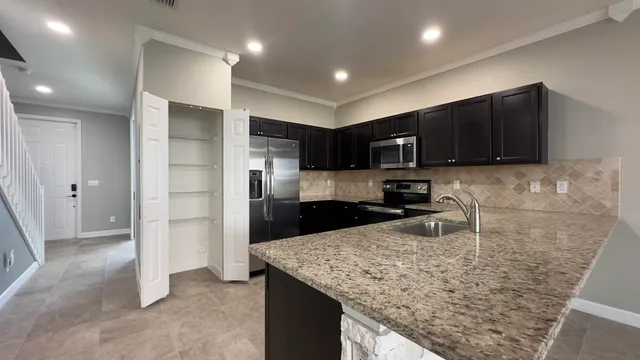 a kitchen with stainless steel appliances granite countertop a refrigerator and a sink