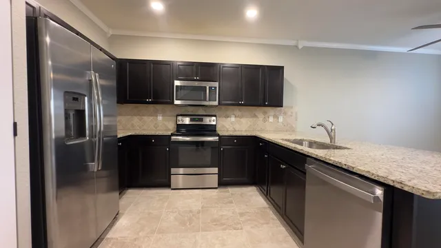 a kitchen with a sink and stainless steel appliances