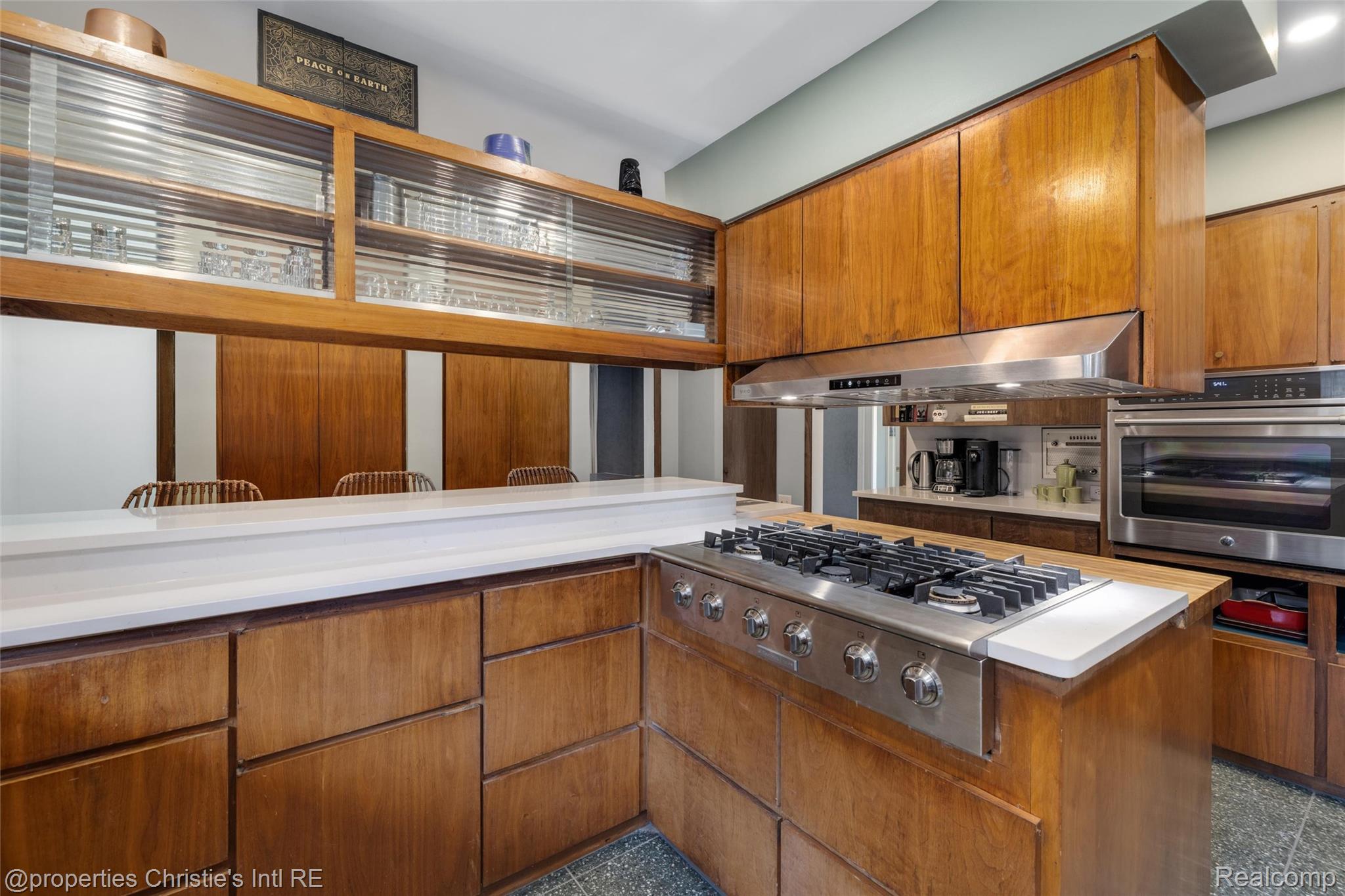 2771 West Seven Mile Road Detroit, MI 48221 - Photo 18 of 57 Kitchen featuring a built-in gas range, stainless steel vent hood, integrated wall oven, wood-finish cabinetry, and solid surface countertops