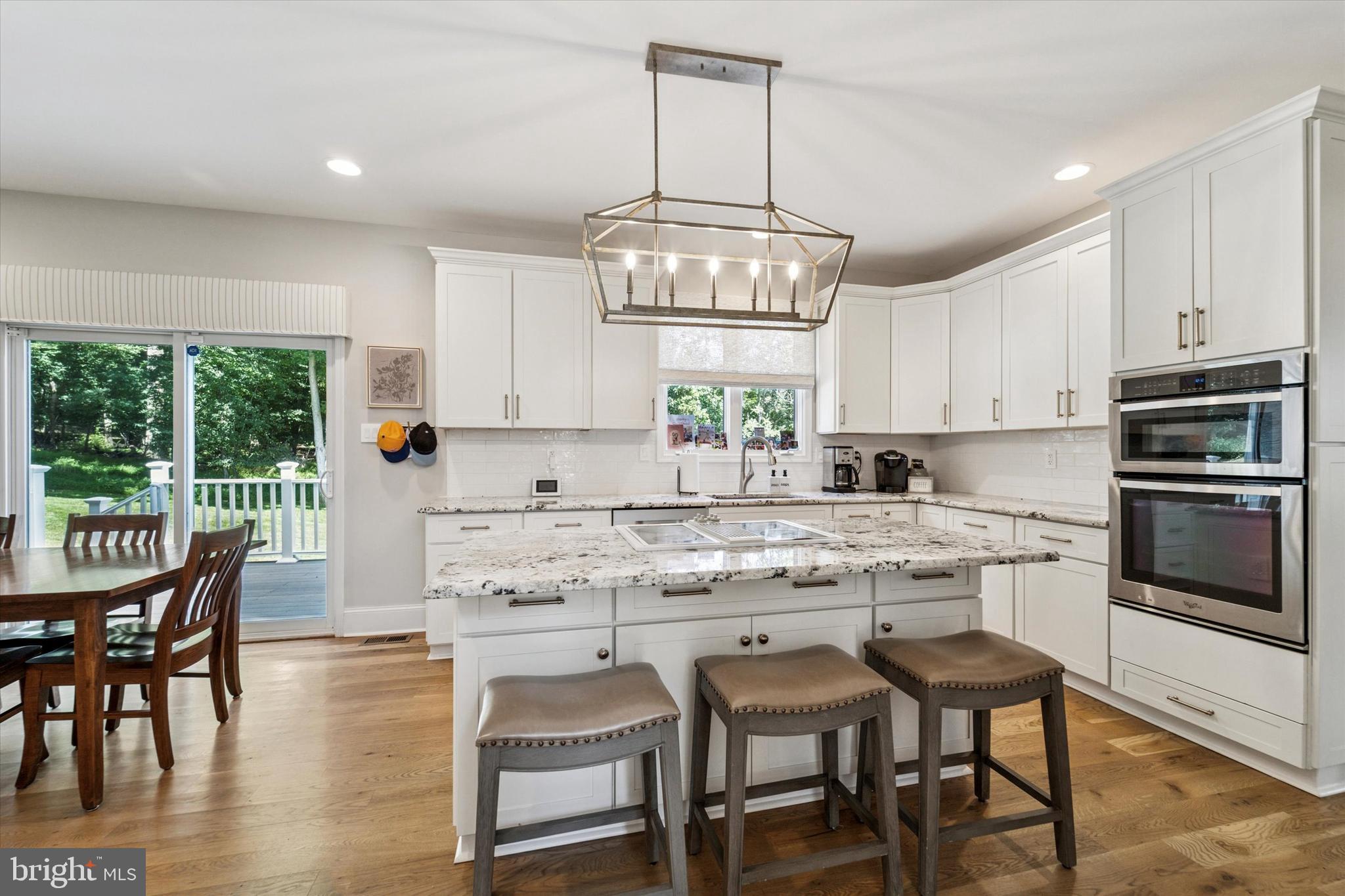 5 Stoney End Road Broomall, PA 19008 - Photo 13 of 48 a kitchen with stainless steel appliances granite countertop a stove a sink a microwave a dining table and chairs with wooden floor