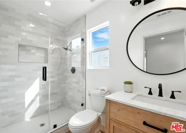 a bathroom with a sink a toilet and a mirror