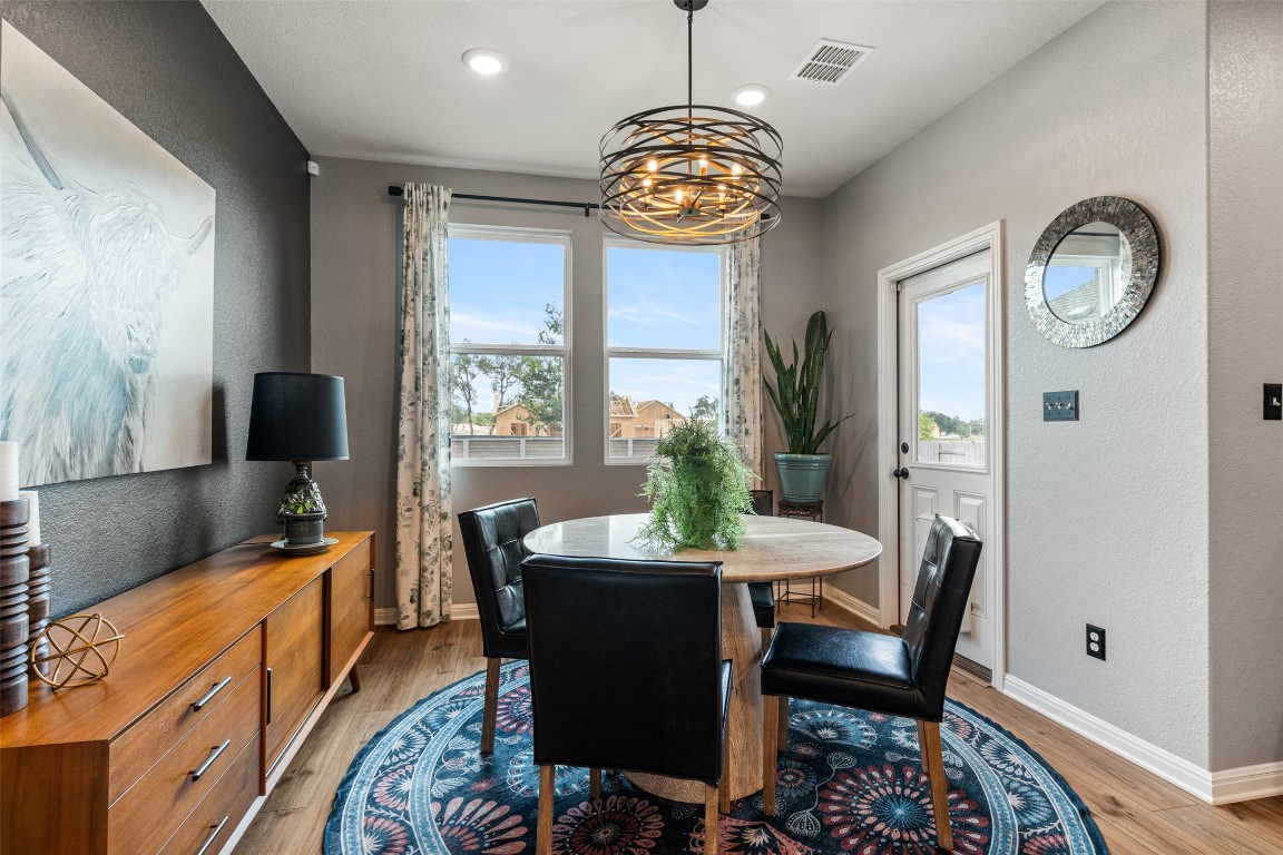 1009 Dog Iron Street Georgetown, TX 78633 - Photo 11 of 39 a view of a dining room with furniture a chandelier and wooden floor