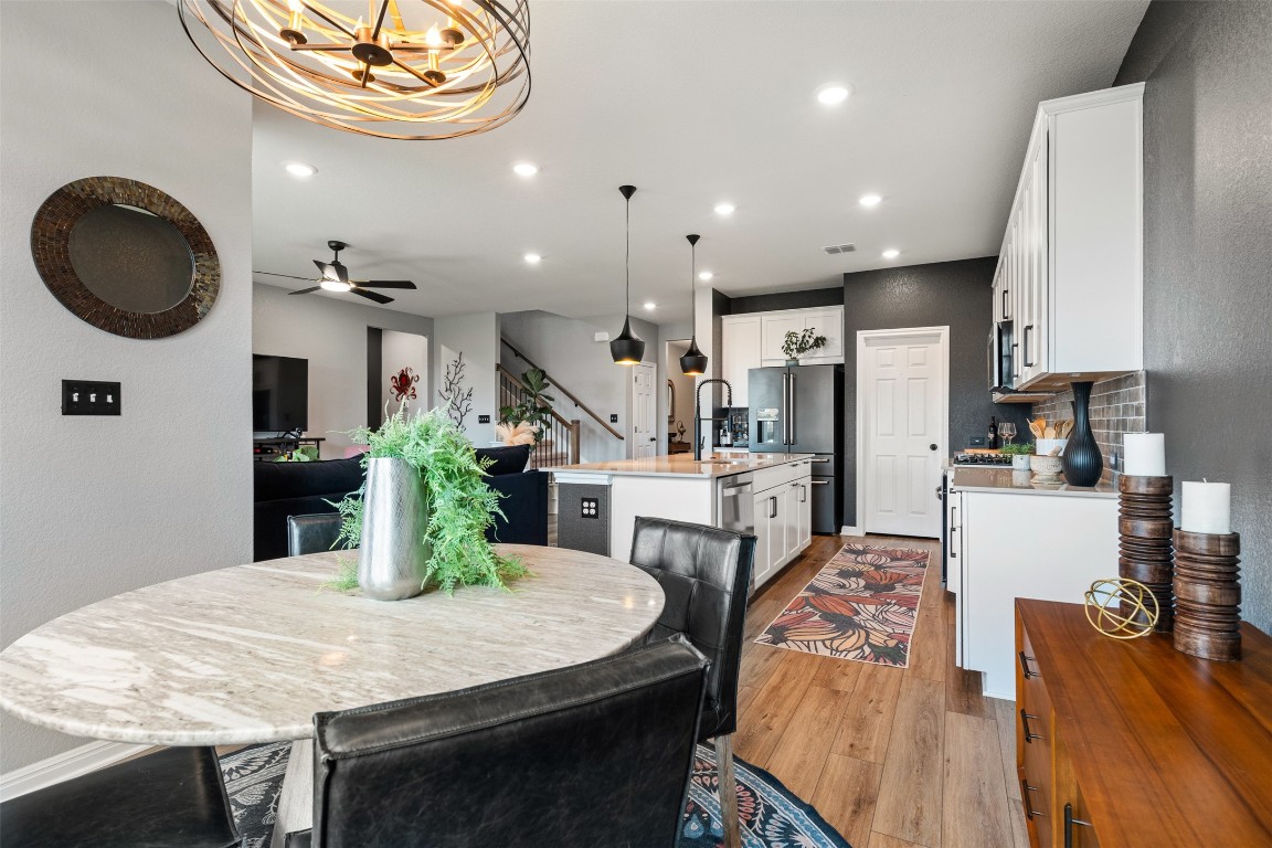 1009 Dog Iron Street Georgetown, TX 78633 - Photo 13 of 39 a kitchen with stainless steel appliances kitchen island granite countertop a table chairs and a refrigerator