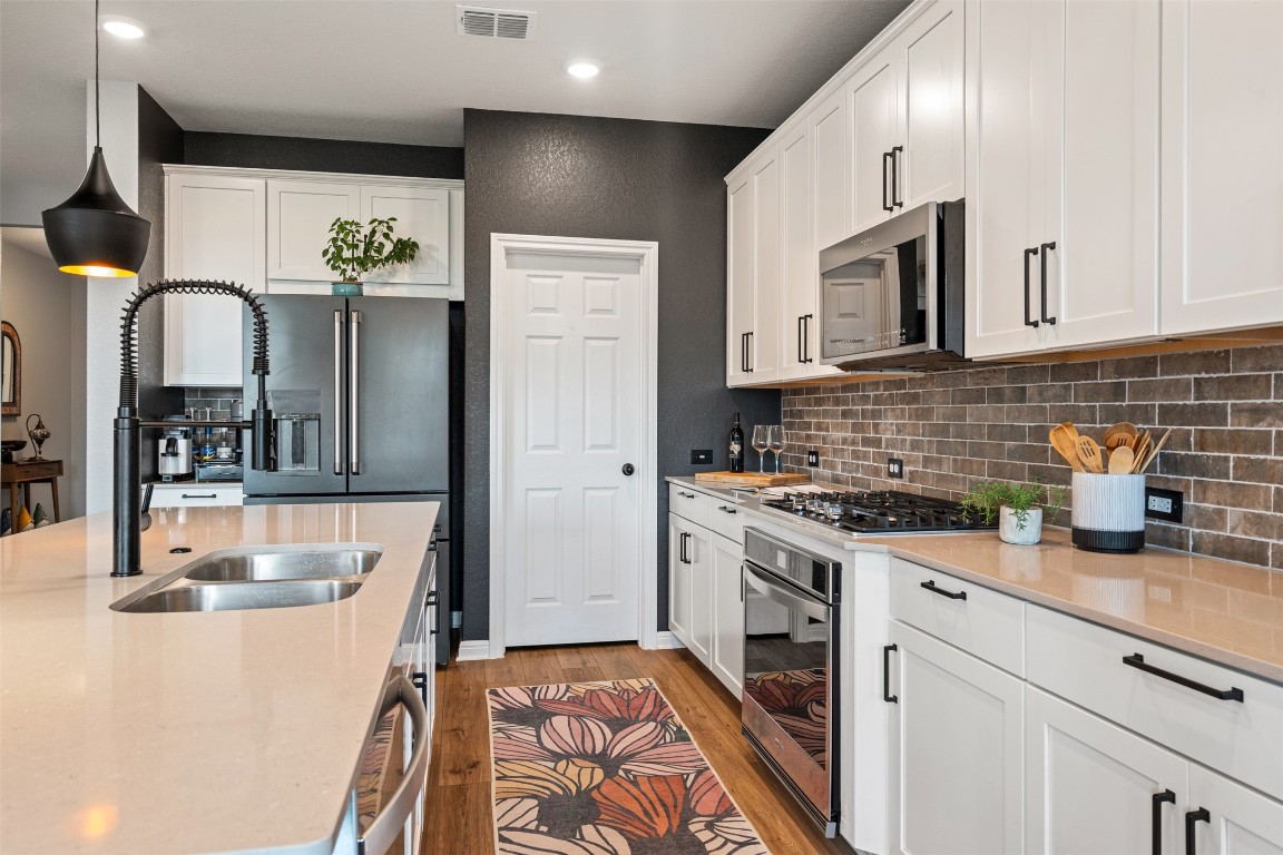 1009 Dog Iron Street Georgetown, TX 78633 - Photo 16 of 39 a kitchen with stainless steel appliances granite countertop a sink stove and cabinets