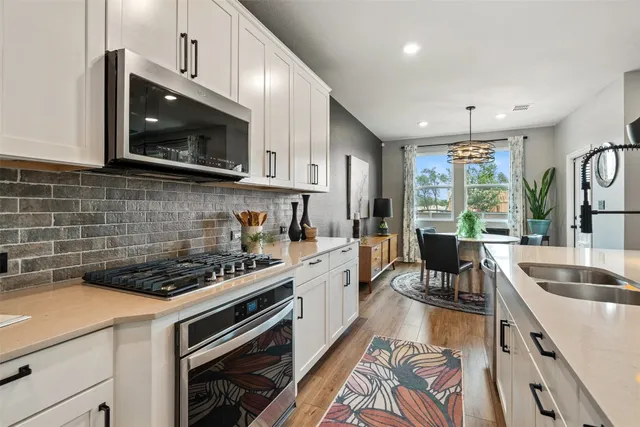 a kitchen with kitchen island granite countertop a sink a counter space appliances and cabinets