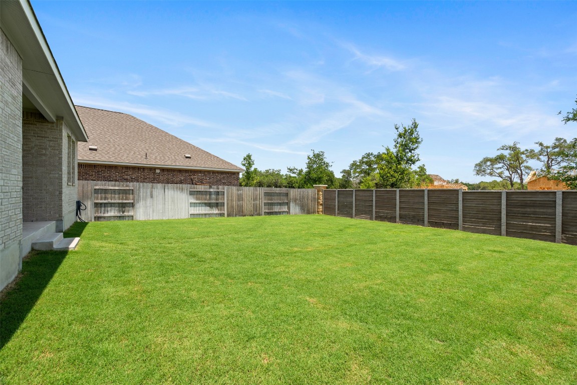 1009 Dog Iron Street Georgetown, TX 78633 - Photo 24 of 39 a view of a backyard with a garden and entertaining space