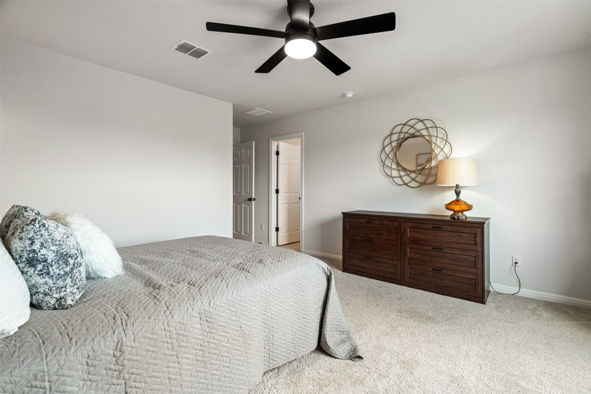 1009 Dog Iron Street Georgetown, TX 78633 - Photo 31 of 39 a bedroom with a bed and a chandelier