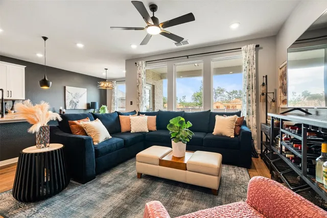 a living room with furniture kitchen and a chandelier
